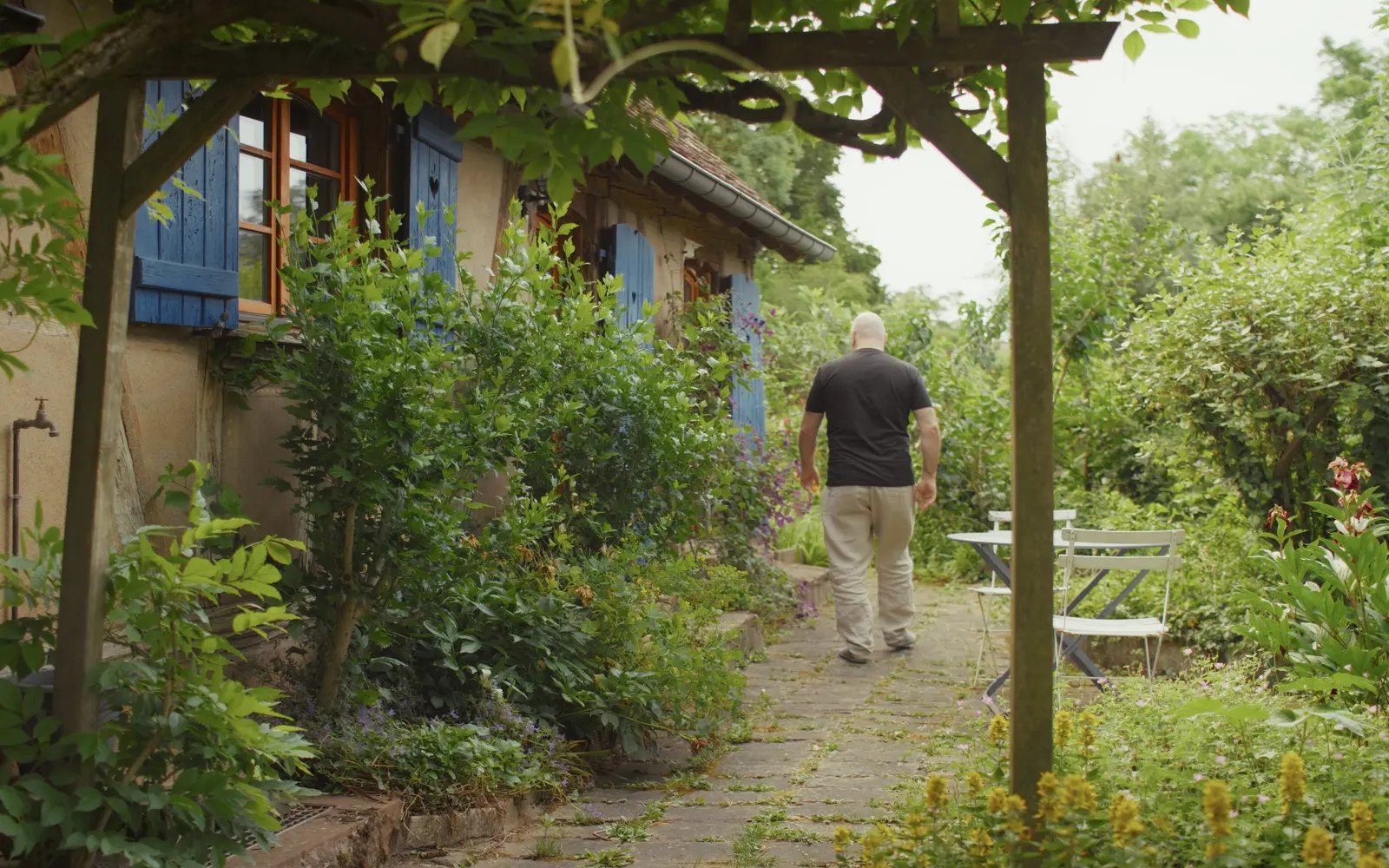 Yves Wauthier s'éloigne sur le chemin fleuri de son jardin